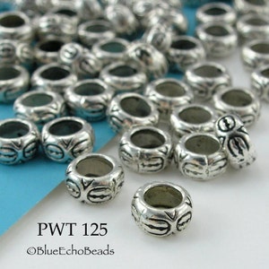 May include: A collection of silver-colored metal beads. Each bead is cylindrical with etched patterns and a central hole. The text "PWT 125" and "©BlueEchoBeads" is visible.