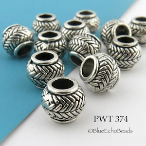 May include: A group of 12 silver metal beads with a woven design. The beads are round and have a hole in the center. PWT 374 ©BlueEchoBeads