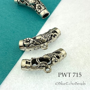 May include: Silver tone metal end caps with a detailed design of a fish and floral accents. The end caps are designed to be used for jewelry making. The text "PWT 715 ©BlueEchoBeads" is visible in the image.