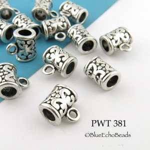 May include: Silver tone metal bead caps with a decorative floral design. The caps have a small loop on the top for attaching to jewelry.