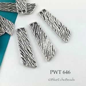 May include: Silver-toned metal jewelry components with a textured, linear pattern. Each piece is rectangular with angled ends and two holes for stringing. The text "PWT 646" and "©BlueEchoBeads" are visible.