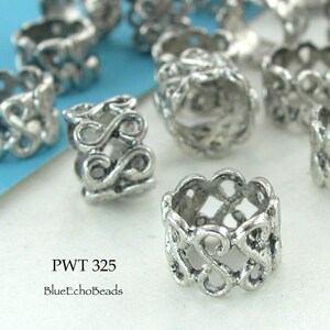 May include: Silver metal bead caps with intricate, openwork designs. The bead caps are about 1/2 inch in diameter and have a delicate, filigree pattern. PWT 325 BlueEchoBeads.