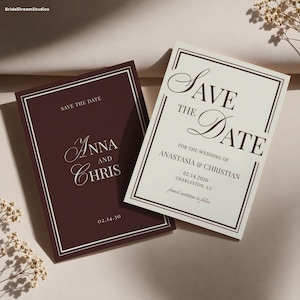 May include: Two rectangular save the date cards with double-line borders. One card is deep burgundy with white text reading Anna and Chris 02.14.30. The other is cream with dark burgundy text reading Save the Date for the wedding of Anastasia & Christian.