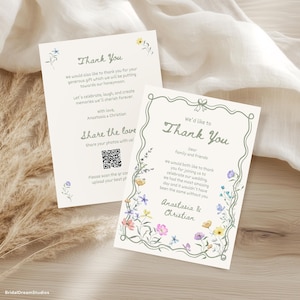 May include: Two cream-colored thank you cards with floral illustrations and text. The cards feature the text "Thank You" and "Share the love" with a QR code. The cards are decorated with watercolor flowers in shades of yellow, pink, and purple.