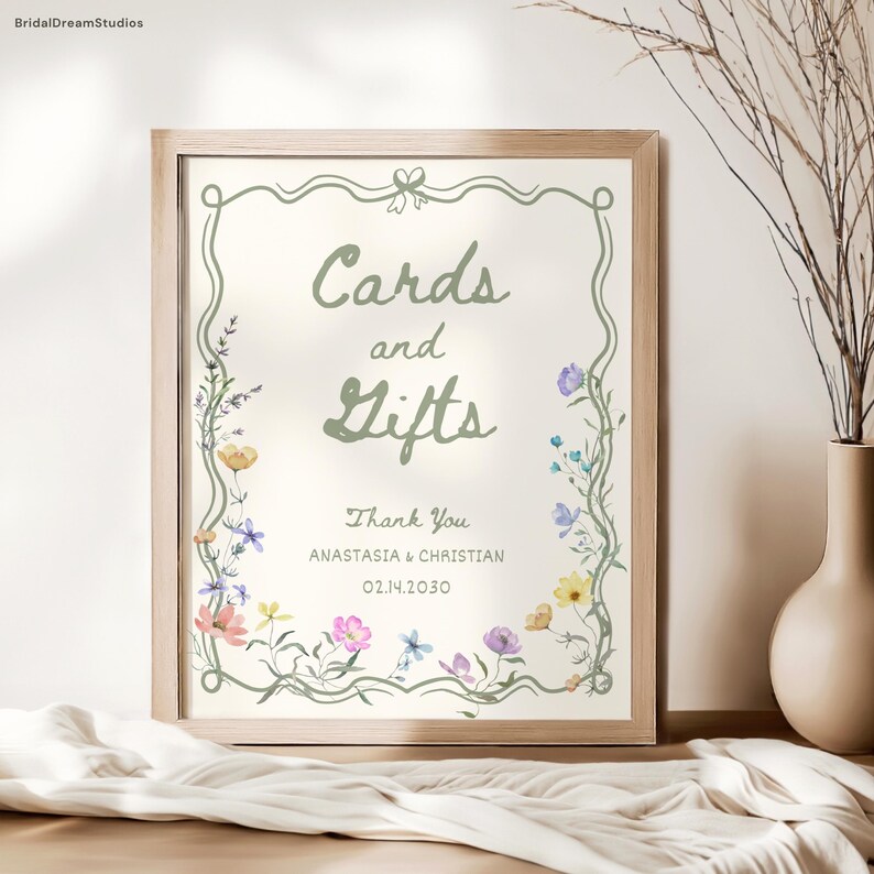 May include: A framed sign with the words "Cards and Gifts" in a script font, surrounded by a floral border. The sign also includes the text "Thank You" and the names Anastasia & Christian, with the date 02.14.2030.