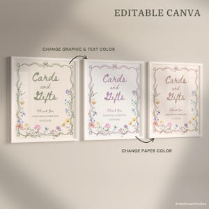 May include: Three framed signs with the text "Cards and Gifts" in elegant script, surrounded by floral illustrations. The signs are in different color schemes, including green, purple, and peach, with the text "Thank You" and a date below.