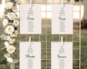 May include: A gold wire grid displays four cards with guest names, held by white clips. Each card has a green illustration of stacked glasses and a table number: One, Two, Three, and Four. White roses and greenery decorate the side.