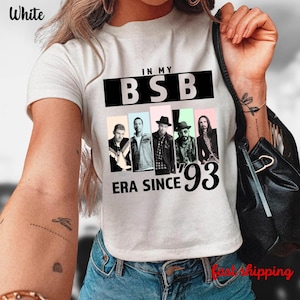 May include: White t-shirt with a graphic featuring the text "IN MY BSB ERA SINCE '93" and images of five men. The shirt has short sleeves and is made of a soft material.