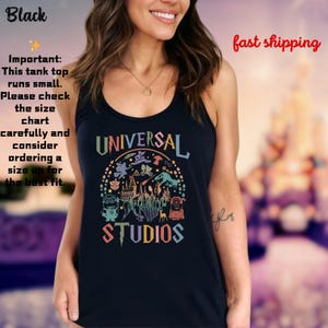 May include: A black tank top with a colorful graphic of the Universal Studios logo and various characters from popular movies and TV shows. The text "UNIVERSAL STUDIOS" is printed in a rainbow font.