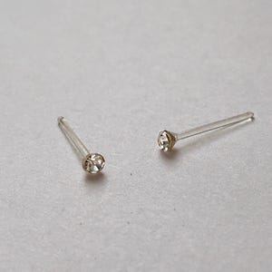 Peut inclure: Deux clous de nez transparents avec un petit strass transparent &agrave; l'extr&eacute;mit&eacute; de chaque clou.