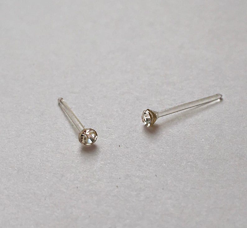Peut inclure: Deux clous de nez transparents avec un petit strass transparent &agrave; l'extr&eacute;mit&eacute; de chaque clou.