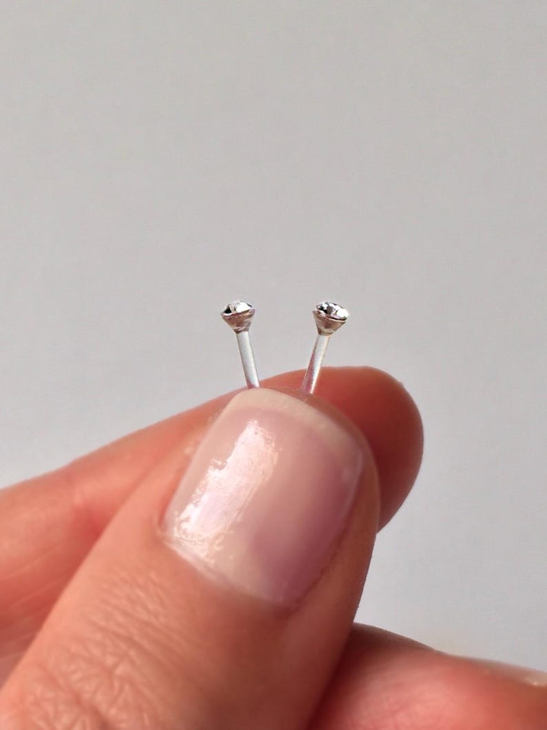 Peut inclure: Deux clous de nez transparents avec de petits strass transparents au sommet.