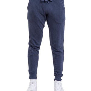 May include: A pair of dark blue sweatpants with a drawstring waist and side pockets. The sweatpants are made of a soft, comfortable fabric and have a relaxed fit.