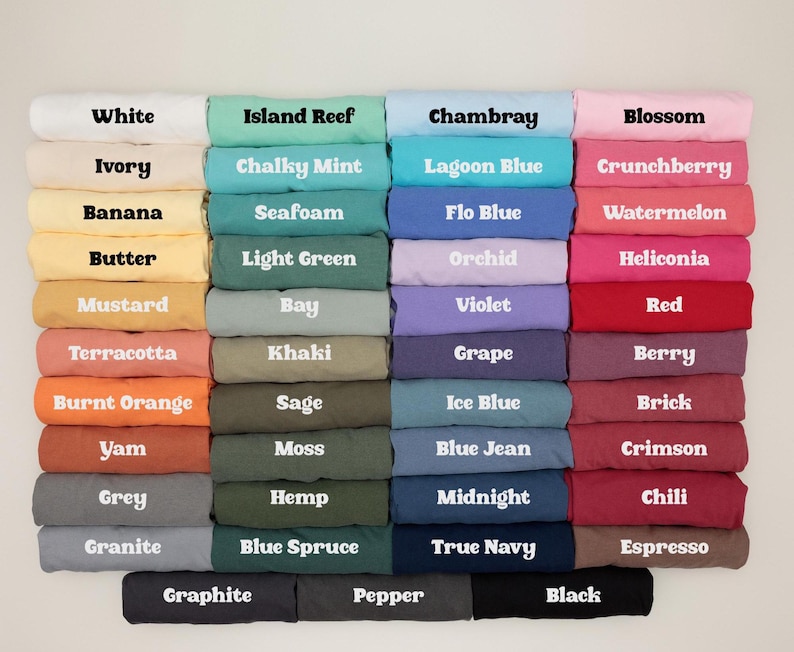 May include: A color chart displaying a variety of folded fabric samples. The chart includes a wide range of colors, from white and ivory to black and espresso. Each color is labeled with its name, such as "Island Reef," "Chambray," and "Berry."