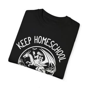 May include: Black t-shirt with a white graphic of a woman riding a dragon with the text "Keep Homeschool" around the graphic.