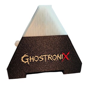 May include: A pyramid-shaped object with a white translucent top section and a textured black base. The text GHOSTRONIX is printed on the front in a stylized font, with the letter X highlighted in red. A small white circular button protrudes from the side.