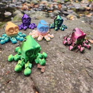 Pode incluir: Um conjunto de seis chaveiros de polvo coloridos. Cada polvo é feito de plástico de uma cor diferente, incluindo roxo, azul, rosa, amarelo, verde e vermelho. Os chaveiros de polvo têm aproximadamente 5 cm de altura e têm um pequeno anel de metal para prender as chaves.