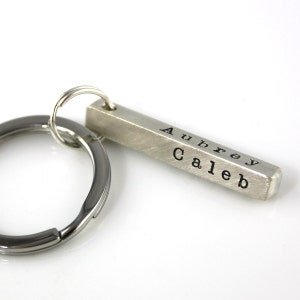 May include: Silver bar keychain with the names Aubrey and Caleb engraved on it.