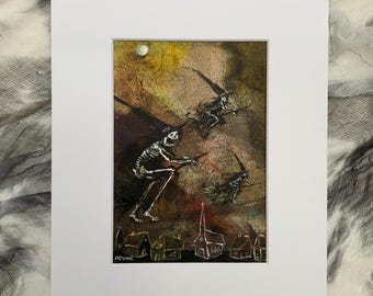 May include: A matted art print featuring a dark, textured painting of three skeletal figures riding broomsticks across a moody, yellow and brown sky above a small village. The artist signature Irvine is visible in the bottom left corner of the artwork.