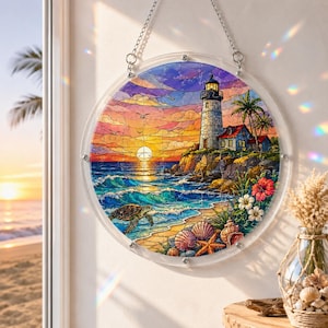 Puede incluir: Obra de arte circular de vidriera que representa una escena costera con un faro, olas del oc&eacute;ano y una puesta de sol. La obra incluye una tortuga, conchas marinas y flores tropicales. La pieza est&aacute; enmarcada en un borde circular transparente y cuelga de una cadena.