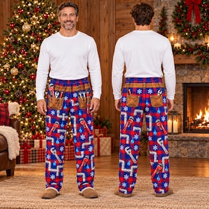 May include: Long-sleeve white shirt and plaid pajama pants featuring a repeating pattern of silver pipes, red wrenches, blue water droplets, and white snowflakes. The pants include a printed brown tool belt graphic with pockets.
