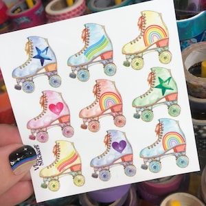 May include: A sheet of colorful roller skate stickers. Each skate features a different design, including rainbows, stars, and hearts. The stickers are in shades of blue, pink, yellow, and green. The text "Vivi Stickers" is visible on the sheet.