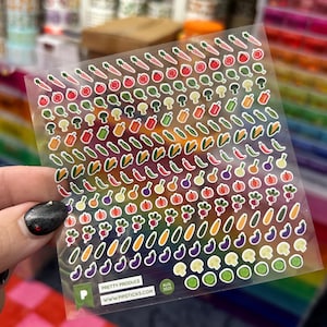 May include: A sheet of colorful vegetable stickers, including carrots, tomatoes, broccoli, peppers, and more. The stickers are on a clear backing with the text "PRETTY PRODUCE" and "AUG 2025" visible. The website address is also printed on the sticker sheet.