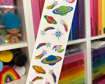 May include: A sheet of colorful, glittery stickers featuring planets, stars, and rainbows. The stickers are on a white background and are perfect for adding a touch of whimsy to any project.