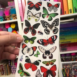 May include: A sheet of colorful butterfly stickers with a variety of designs and colors, including red, green, black, and white. The stickers are perfect for adding a touch of whimsy to any project.