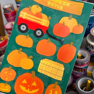 May include: A green sheet with a variety of pumpkin stickers. The stickers include pumpkins in a red wagon, pumpkins with jack-o-lantern faces, and a hay bale. The text "Pumpkin Patch" is written on a wooden sign at the top of the sheet.