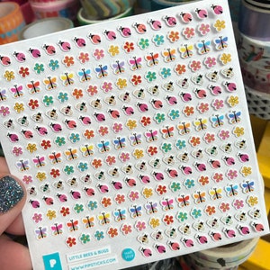 May include: A sheet of colorful stickers featuring bees, butterflies, and flowers. The stickers are on a white background and are arranged in rows. The sheet is labeled "Little Bees & Bugs" and "www.pipssticks.com".