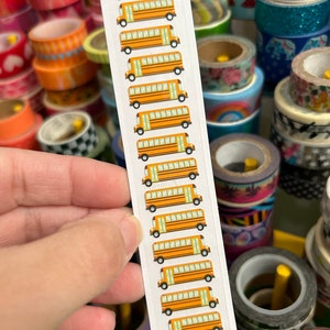 May include: A sheet of stickers featuring a repeating pattern of yellow school buses with black outlines and windows. The stickers are on a white background with a green and white letter 'P' at the bottom.