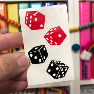 May include: Four temporary tattoos of dice. Two dice are red with white dots and two dice are black with white dots.