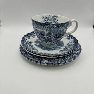 May include: A blue and white teacup and saucer set with a floral pattern. The cup and saucer have a scalloped edge.