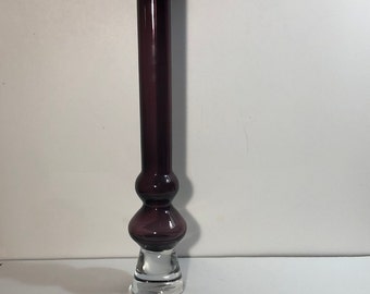 May include: A tall, purple glass vase with a clear glass base. The vase has a bulbous middle section.