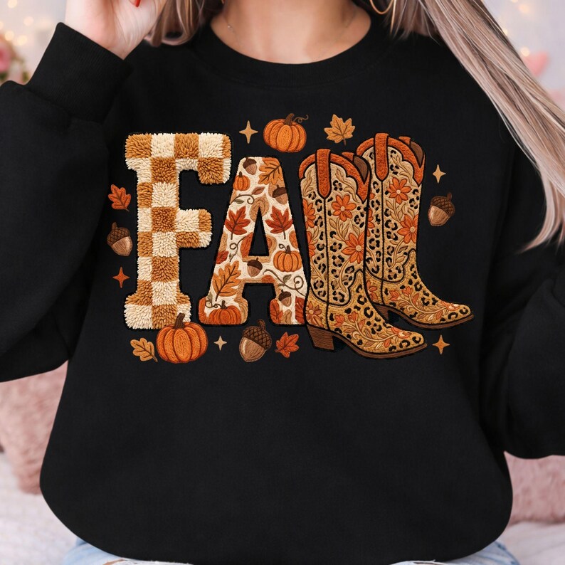K&ouml;nnte beinhalten: Schwarzes Sweatshirt mit dem Wort "FALL" in einem Herbst-Design. Das "F" hat ein braun-wei&szlig;es Karomuster, das "A" ist mit Bl&auml;ttern und K&uuml;rbissen gef&uuml;llt, und das "LL" sind ein Paar Cowboy-Stiefel mit Blumen- und Leopardenmuster.