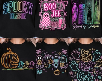 May include: A collection of six black sweatshirts featuring various Halloween-themed graphic prints in neon colors, including text like Spooky Season and Boo Jee, alongside illustrations of ghosts, pumpkins, cats, and gothic architecture.
