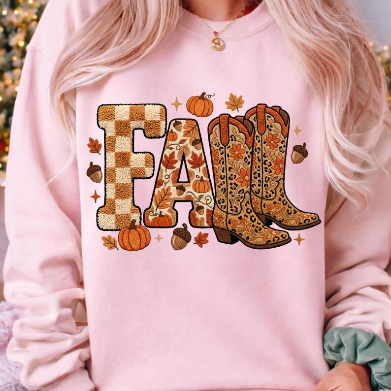 K&ouml;nnte beinhalten: Hellrosa Sweatshirt mit dem Wort "FALL" in einem herbstlichen Design. Der Buchstabe "F" hat ein braunes und beiges Karomuster. Der Buchstabe "A" ist mit Herbstbl&auml;ttern und K&uuml;rbissen gef&uuml;llt. Der Buchstabe "L" ist ein Paar Cowboystiefel.