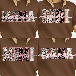 May include: Four brown t-shirts with different names printed on them. The names are "MAMA", "GIGI", "MIMI", and "NANA". Each name is in a unique font and design, with leopard print and pink heart accents.