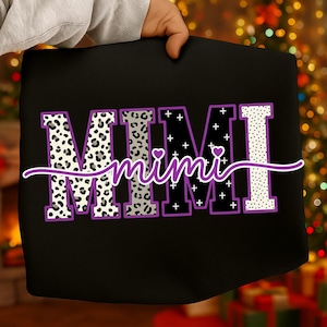 May include: Black tote bag with the word "MIMI" in large, bold letters. The letters have various patterns, including leopard print, plus signs, and polka dots. The word "mimi" is written in cursive underneath, with a heart above the "i".
