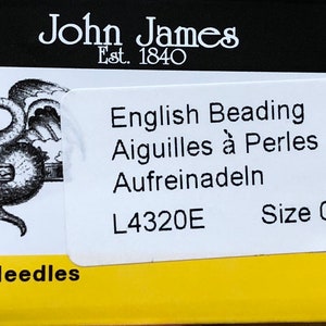 May include: A white label with black text that reads "English Beading, Aiguilles à Perles, Aufreinadeln, L4320E, Size 010" on a yellow background with black text that reads "25 Needles".
