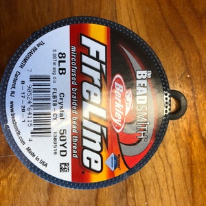 May include: A spool of FireLine microfused braided bead thread in a red, black, and white label. The label reads "FireLine", "Berkley", "The Beadsmith", "Microfused", "Crystal", "8LB", "50YD", "FL.BT8-CY", "1389516", and "Made in USA".