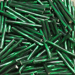 May include: A pile of green glass rods, also known as glass beads or glass sticks, used for making jewelry and other crafts.