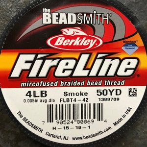 May include: A spool of black FireLine microfused braided bead thread by Berkley, with a red and white label. The label reads "4LB Smoke 50YD 0.005in avg.dia FLBT4-42 1389709".