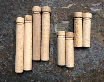 May include: A set of eight wooden spools in various sizes. The spools are made of light brown wood and have a smooth, polished finish.