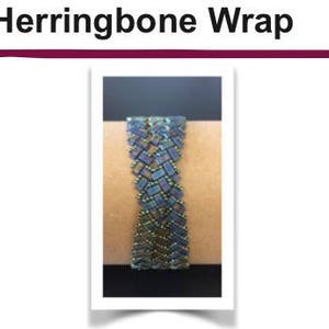 May include: A close-up of a blue and green herringbone bracelet made with small beads. The bracelet is on a person's wrist.