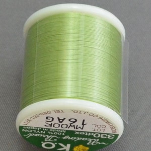 May include: A spool of green nylon beading thread, labeled "KO Beading Thread 330dtex 100% NYLON Made in Japan MWOOR 1 G COL. 2 G KOBAYASHI CO.,LTD. TEL.052-251-3711"