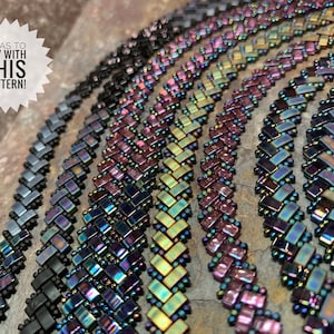 May include: Close-up of several beaded bracelets in a variety of iridescent colors, including black, blue, green, and purple. The bracelets are made with a herringbone stitch pattern. The text "IDEAS TO TRY WITH THIS PATTERN!" is visible in the top left corner of the image.