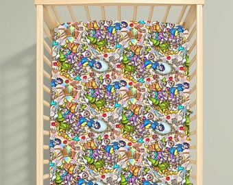 Puede incluir: Una sábana de cuna con un patrón repetitivo de Blancanieves, los siete enanitos, animales del bosque y espejos sobre un fondo claro. El diseño colorido incluye varios personajes en tonos azul, amarillo, rojo y verde sobre una base de tela color crema.