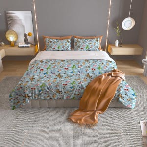 May include: A light blue comforter set featuring a repeating pattern of cartoon characters. The set includes a comforter, two pillow shams, and a brown throw blanket. The bedding is on a bed with a light gray base.